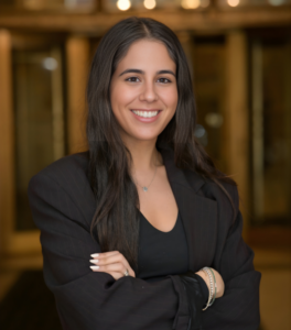 Woman in black business suit standing in front of library books