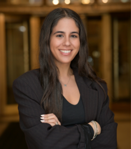 Person wearing a black business suit in front of library books
